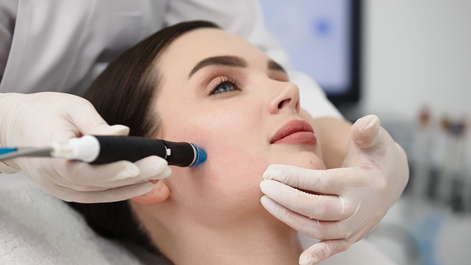 Facial and clinical skin treatment — esthetician performing microdermabrasion