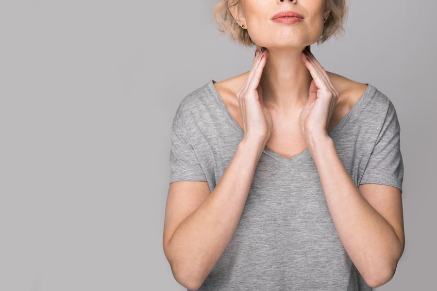 Woman touching her neck and thyroid area